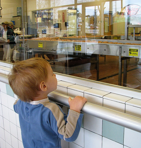 Mesmerized by the process... or more likely, the rows and rows of donuts going under the waterfall of glaze.