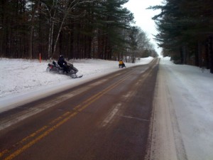 Snow mobilers alongside the road