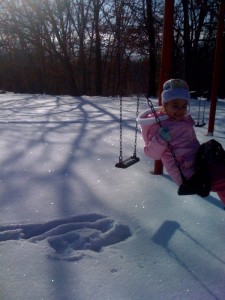 Analise swinging with the bright sunshine reflecting off the snow