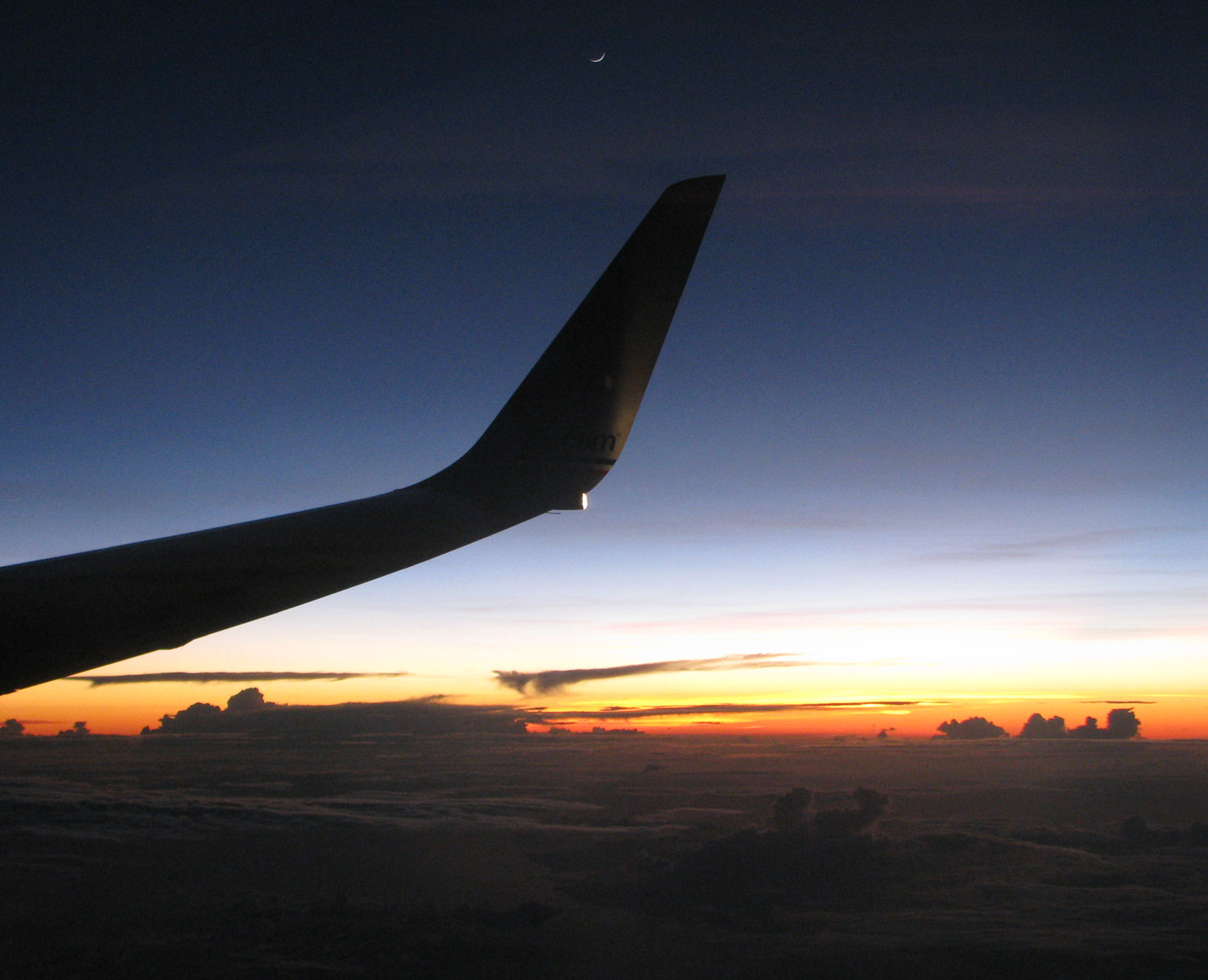 moon, airplane wing, and sunset sky