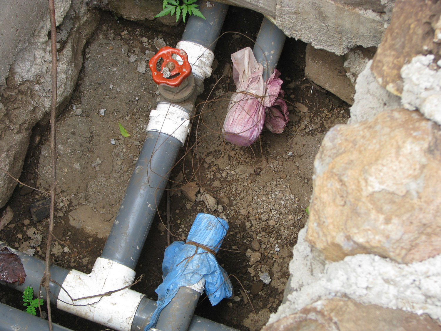 Pipes in the community of La Union ... the red valve pipe has arsenic but is safe for washing clothes, bathing, etc. The blue covered pipe is the drinking water free from arsenic piped from a spring higher up on the volcano.